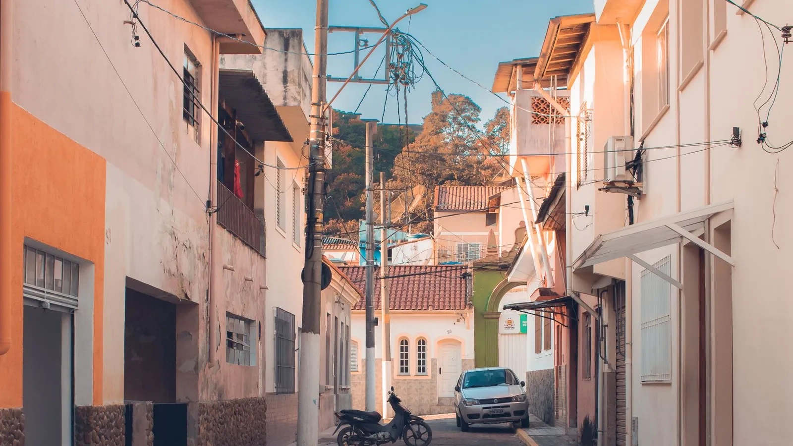 Rua residencial estreita com casas coloridas ao entardecer